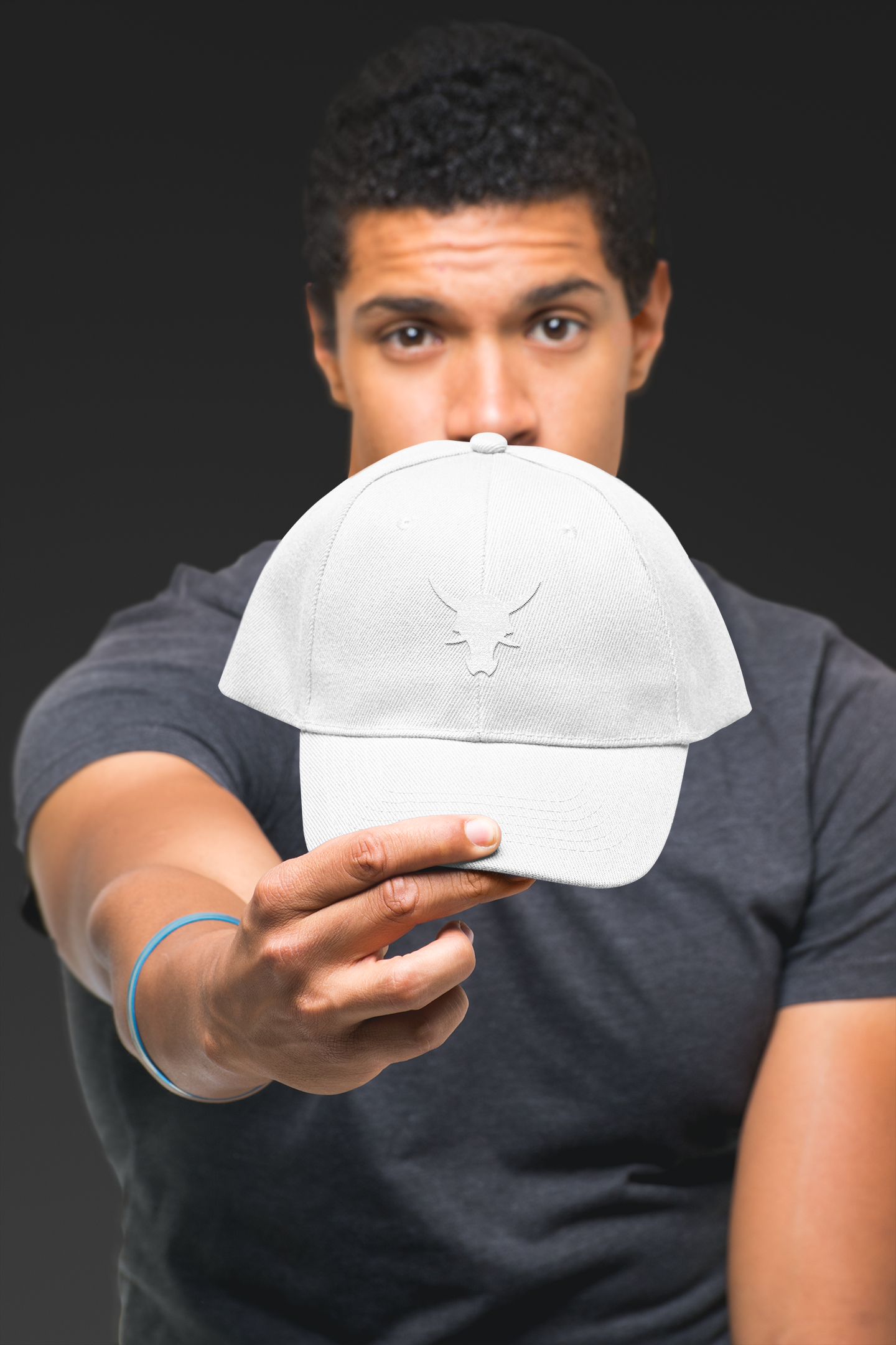 Male model holding retro trucker hat in a studio
