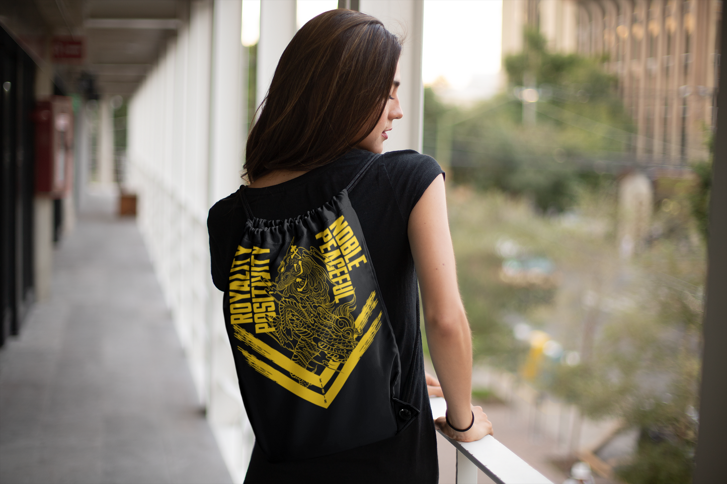 Kirin yellow drawstring bag on female model facing backward at open hallway